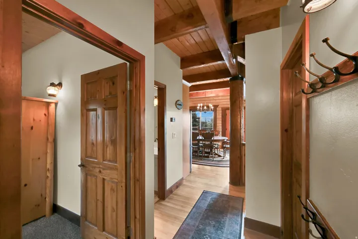 Exposed wood beam ceiling, wood-finish flooring, paneled wood doors, and wood trim throughout