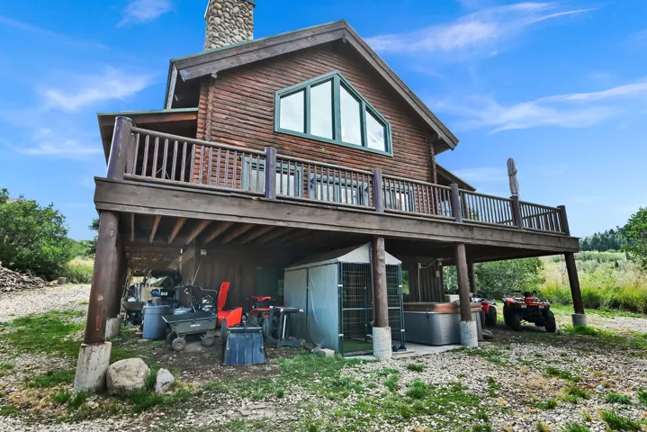 Multi-level wood-sided residence with an expansive wood deck, stone chimney, and a triangular window feature