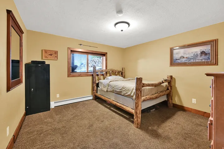 Carpeted flooring, wood-framed window, wood trim, and a ceiling-mounted light fixture