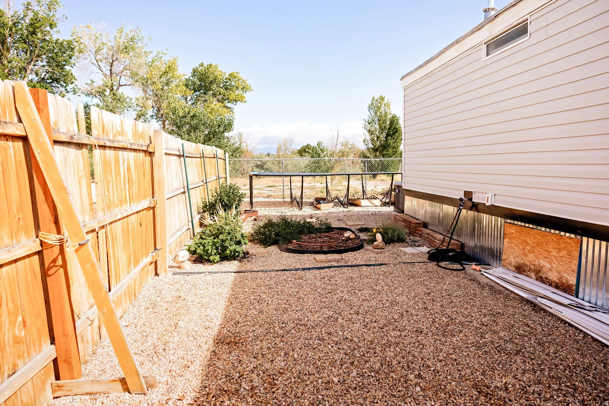 Gravel ground cover with a wood picket fence and corrugated metal skirting