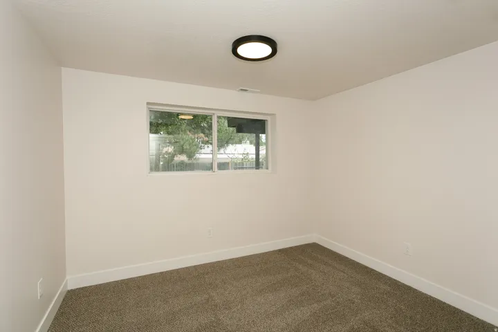 Recessed window, neutral wall finish, wall-to-wall carpet, ceiling-mounted light fixture, and white baseboards