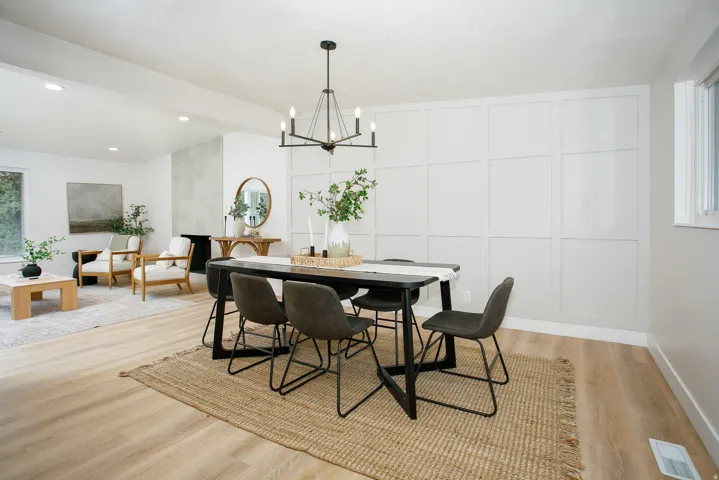 Open-concept living area with wood-finish flooring, recessed lighting, and a prominent board-and-batten accent wall