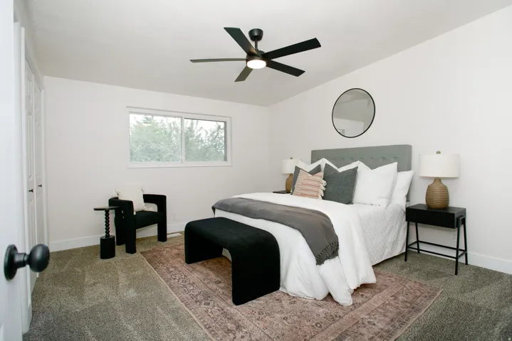 Spacious room featuring a ceiling fan, dual-pane window, and carpet flooring