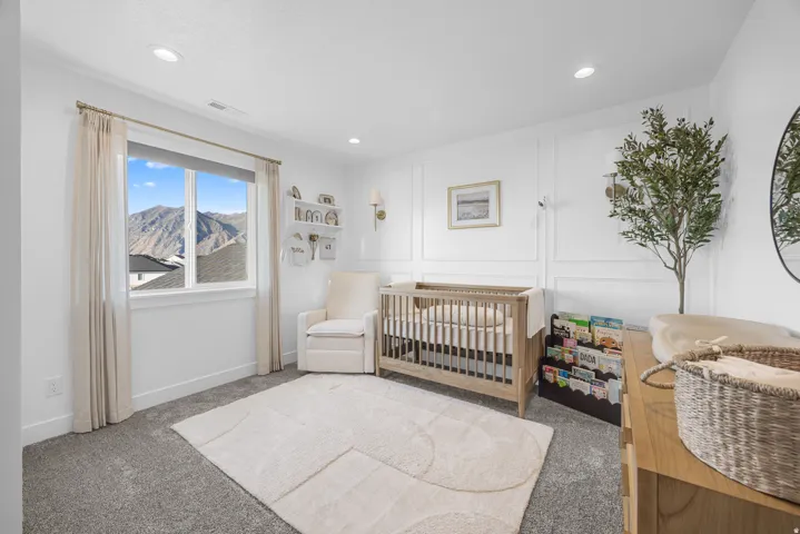 Recessed lighting illuminates the room, featuring a large window with mountain scenery