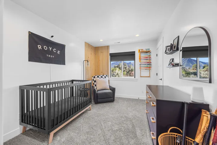 White walls with a wood slat accent, two windows, and carpeting