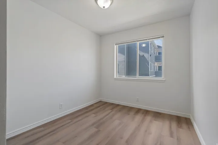 Neutral wall paint, wood-finish flooring, and a flush mount ceiling light
