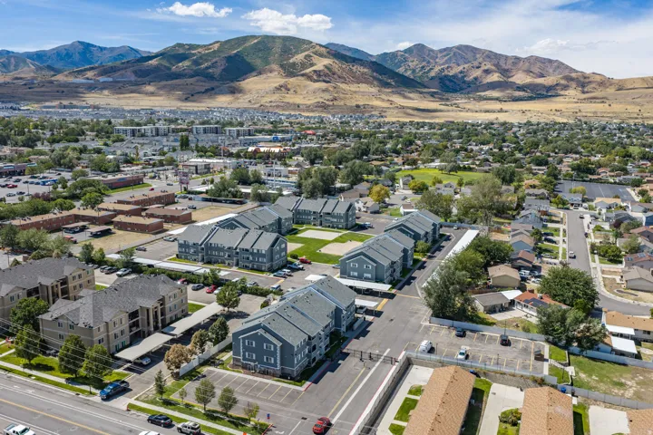 Community buildings with covered parking, surrounded by additional residential structures and mature trees