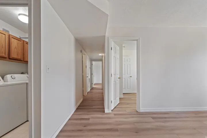 Wood-finish flooring throughout, white baseboards, and interior doors with panel details