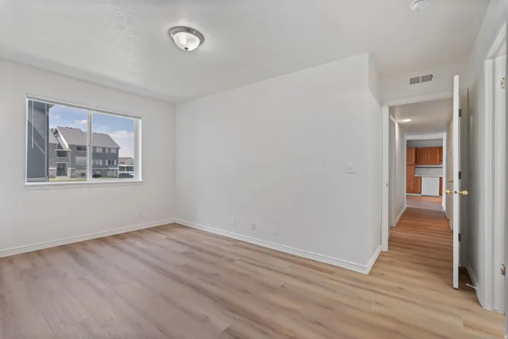 Wood-finish flooring, white walls, and a contemporary ceiling fixture
