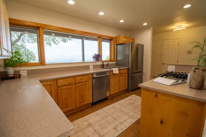 Spacious kitchen featuring extensive counter space, recessed lighting, wood cabinetry, stainless steel appliances, and a gas range