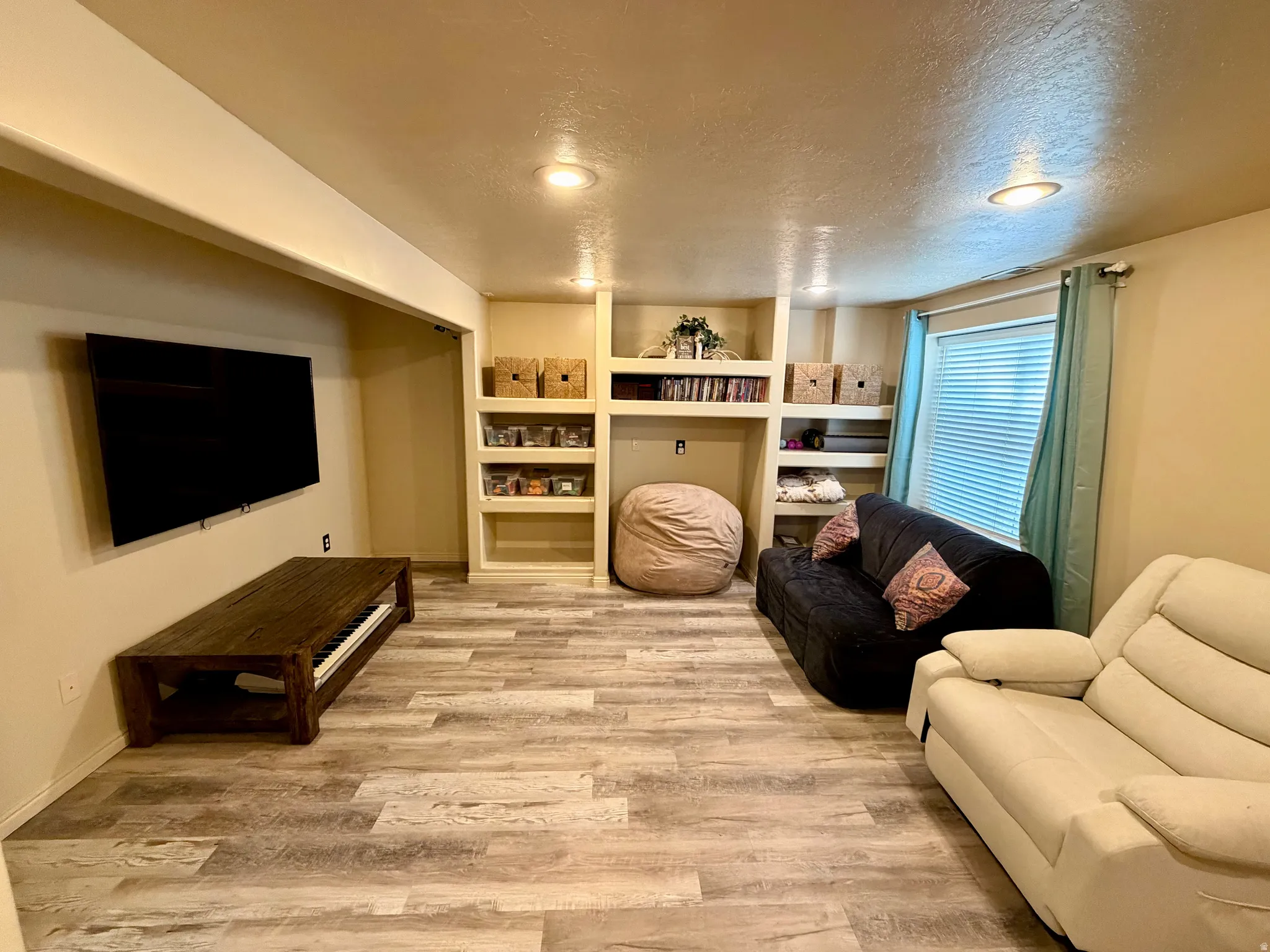 Recessed lighting, built-in shelving, and wood-finish flooring