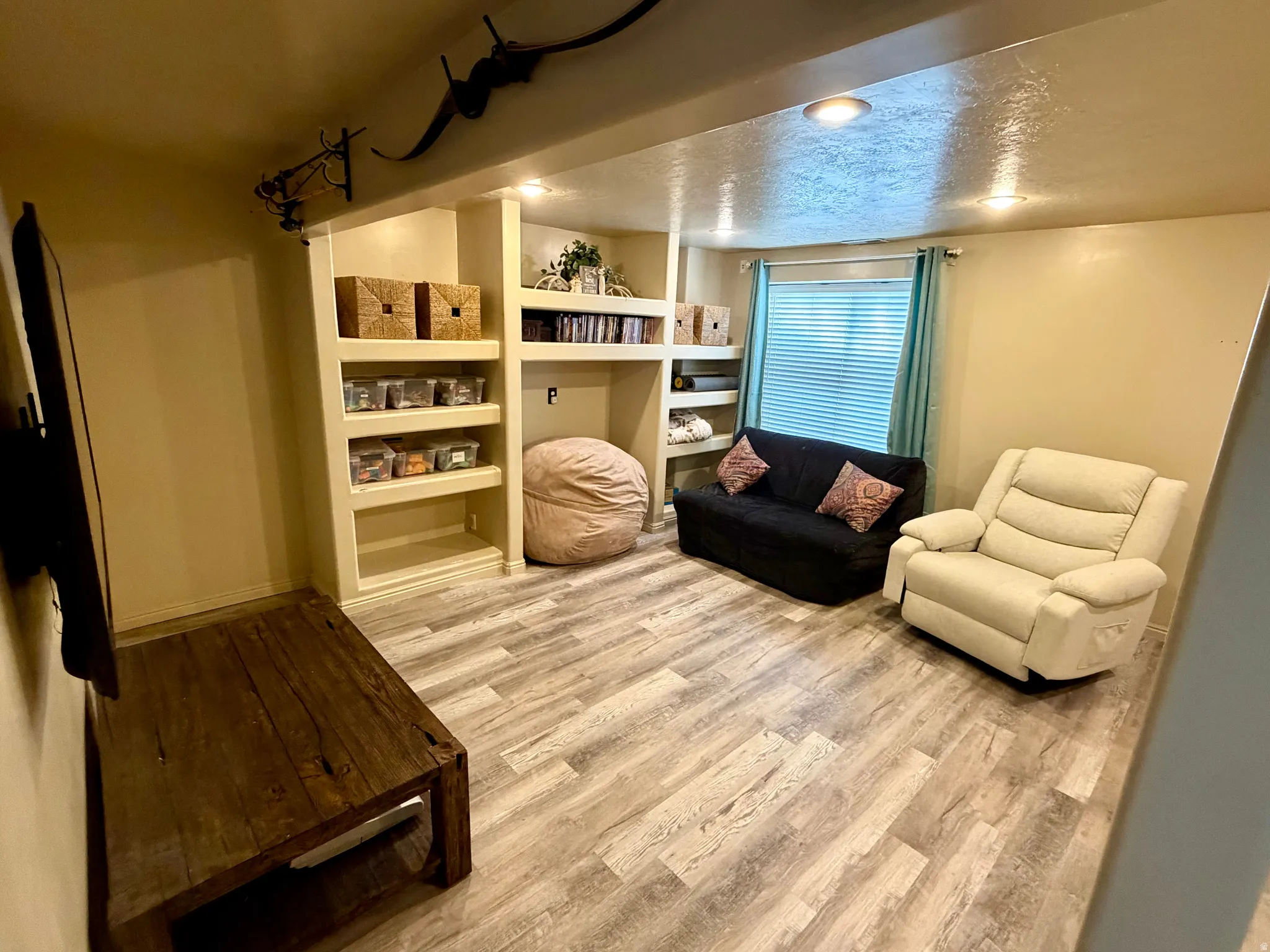 Built-in shelving units, recessed lighting, and wood-finish flooring