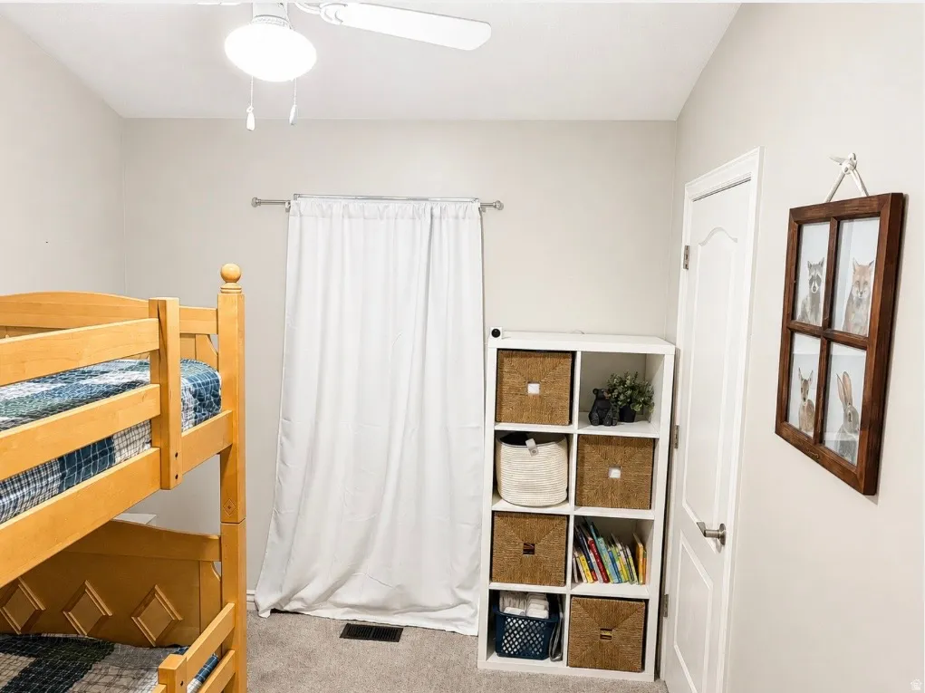 Neutral wall color with ceiling fan, carpet flooring, and white trim door