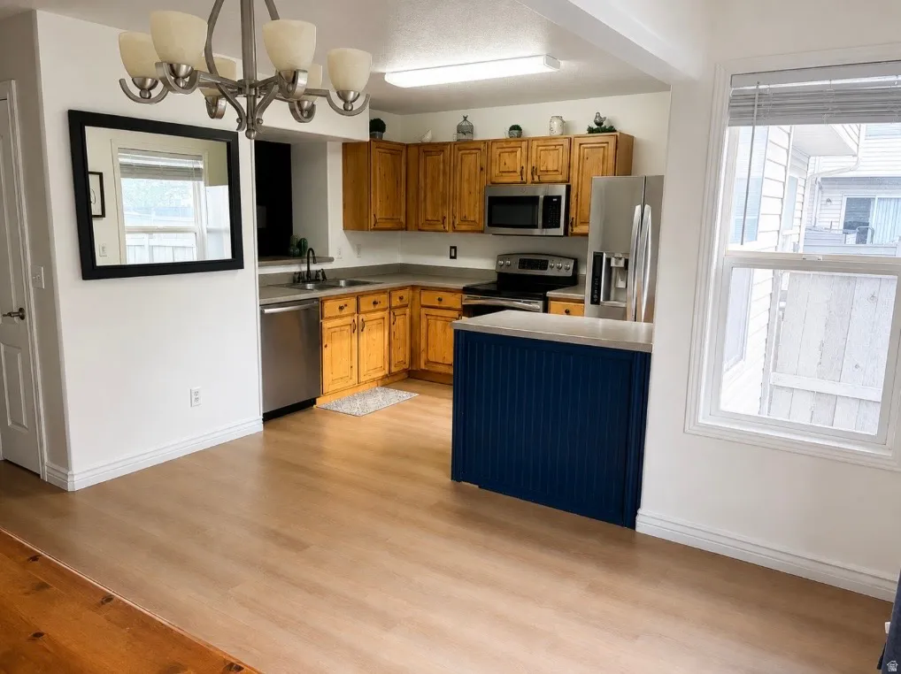 Kitchen featuring wood-finish cabinetry, stainless steel appliances, a center island with a beadboard base, and wood-finish flooring