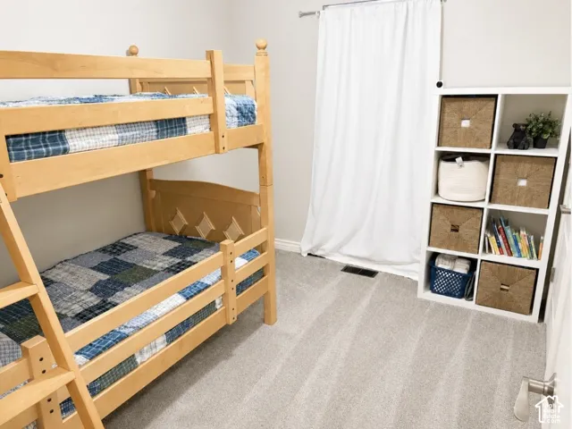 Plush carpet flooring, light neutral wall paint, and a built-in modular storage unit with cubbies