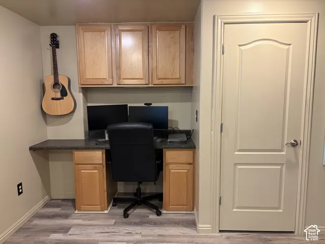 Built-in desk with a dark countertop and ample cabinet storage