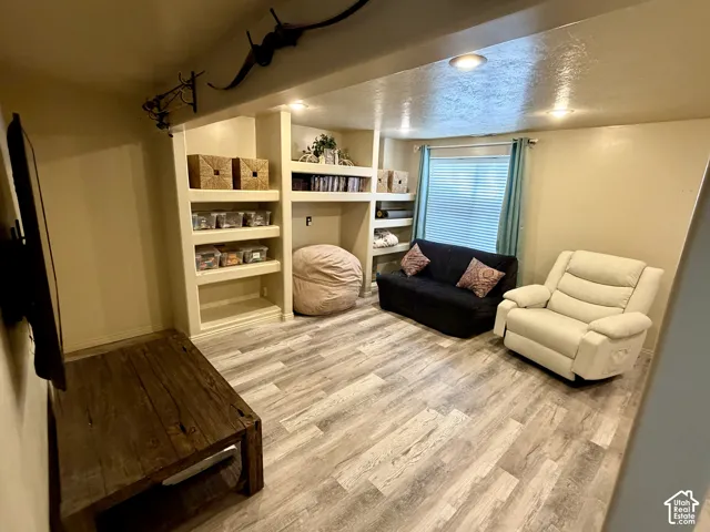 Built-in shelving units, recessed lighting, and wood-finish flooring