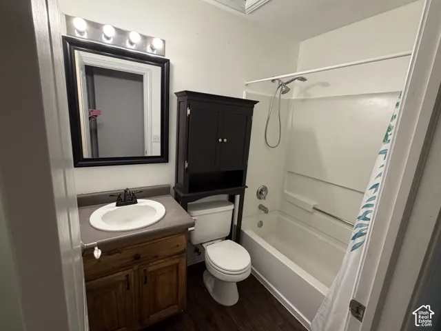 Vanity with wood-finish cabinetry, a drop-in sink, and a dark countertop