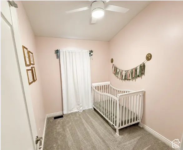 Vaulted ceiling, ceiling fan with integrated lighting, wall-to-wall carpeting, and a window with white drapery