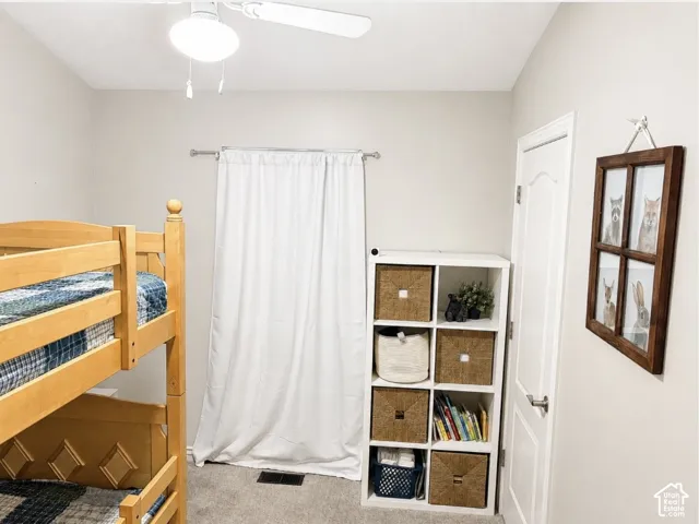 Neutral wall color with ceiling fan, carpet flooring, and white trim door