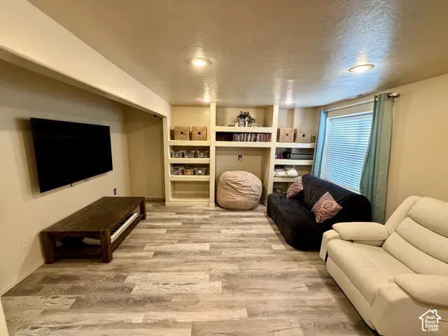 Recessed lighting, built-in shelving, and wood-finish flooring