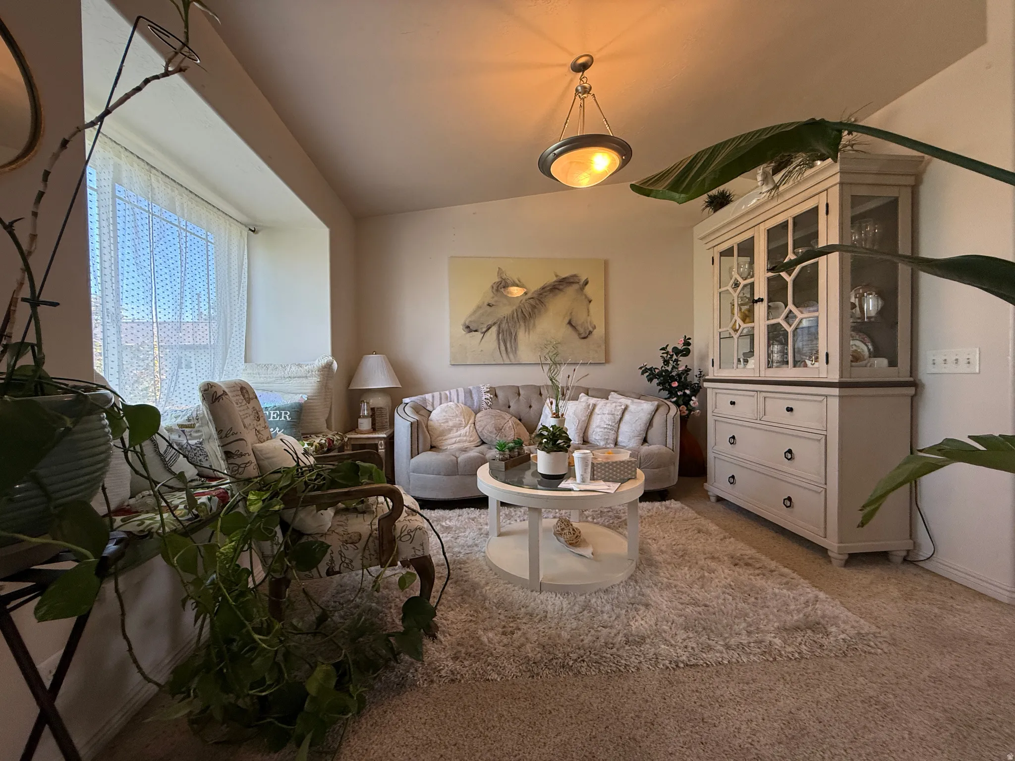 Living room. Expansive bay window, recessed ceiling lighting, light-toned wall finishes, and carpet flooring
