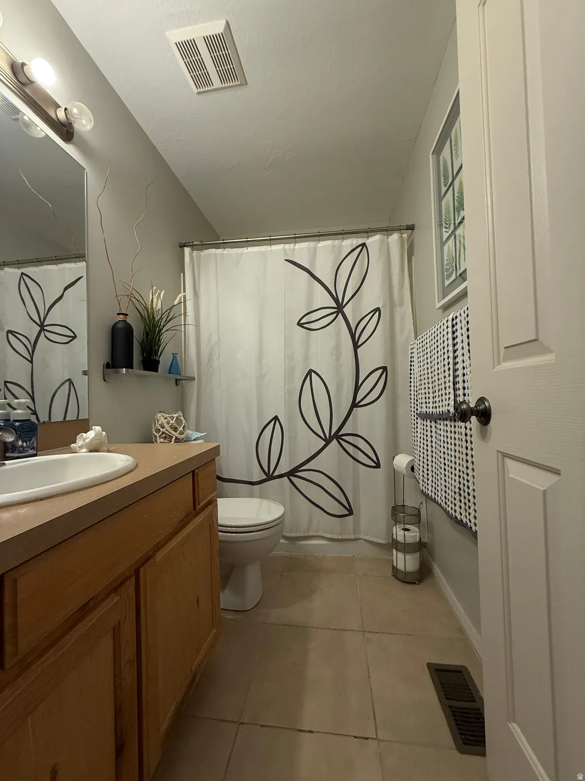Master Bathroom. Wood-finish vanity with an integrated sink, tiled flooring, and a shower/tub combination