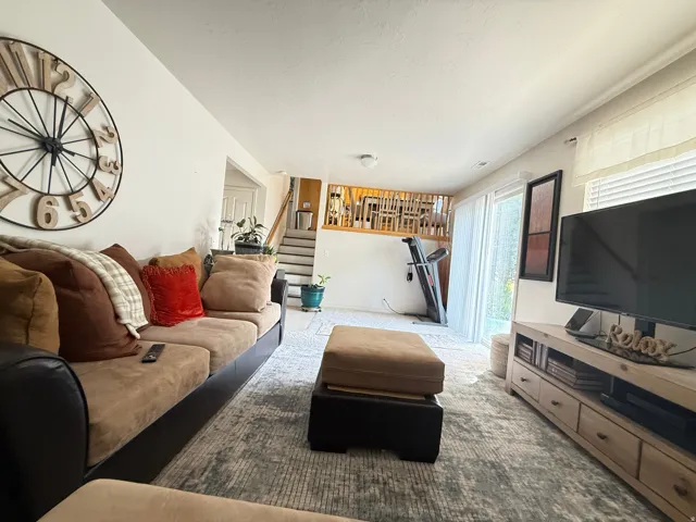 Other view of the Family room area featuring light-colored walls, recessed lighting, and wood-finish media console