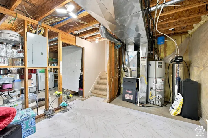 Other view of the Potential 4th bathroom. Finished basement space featuring light-toned flooring, exposed structural elements, built-in storage, and a utility area with mechanical systems