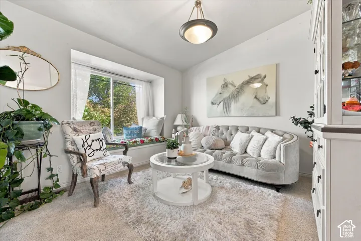 Recessed window seat, overhead light fixture, light-colored wall paint, light-colored carpet, built-in cabinetry with glass panels