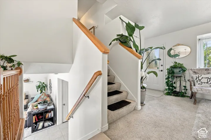 Carpeted staircase with wood handrails and balusters