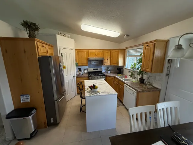 Other Kitchen view featuring wood cabinetry, a center island with a light-toned countertop, and tiled flooring