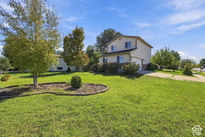 Two-story residence with light-colored siding, an attached garage, and a concrete driveway