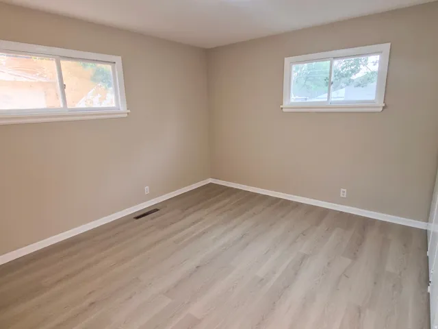 Neutral wall paint, light wood-finish flooring, and white trim