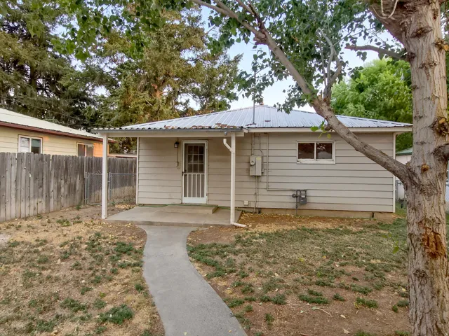 Covered patio entry with concrete walkway, horizontal siding, and metal roof
