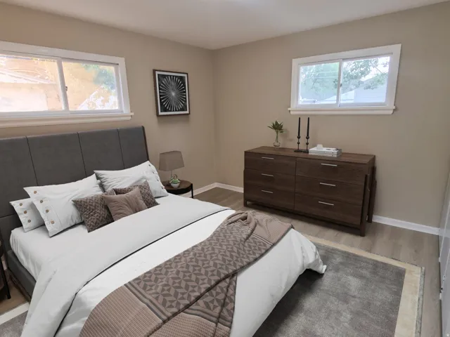 Tan-painted walls with white trim, two windows, and wood-finish flooring