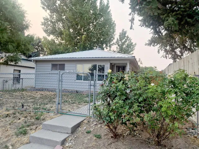 Single-story residence featuring light gray siding and a metal roof