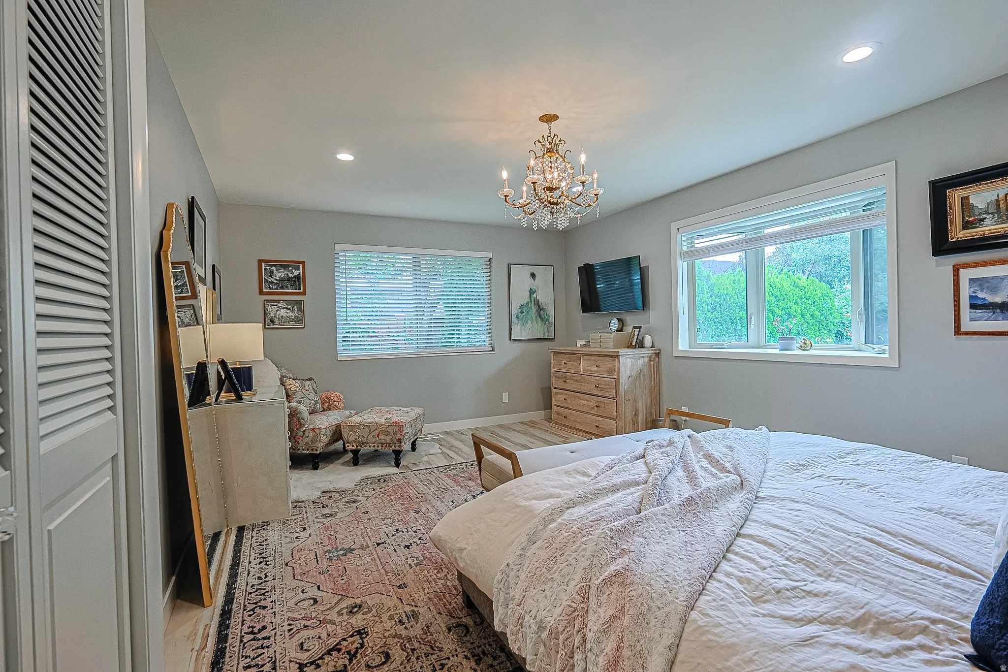 Recessed lighting, wood-finish flooring, and a decorative chandelier
