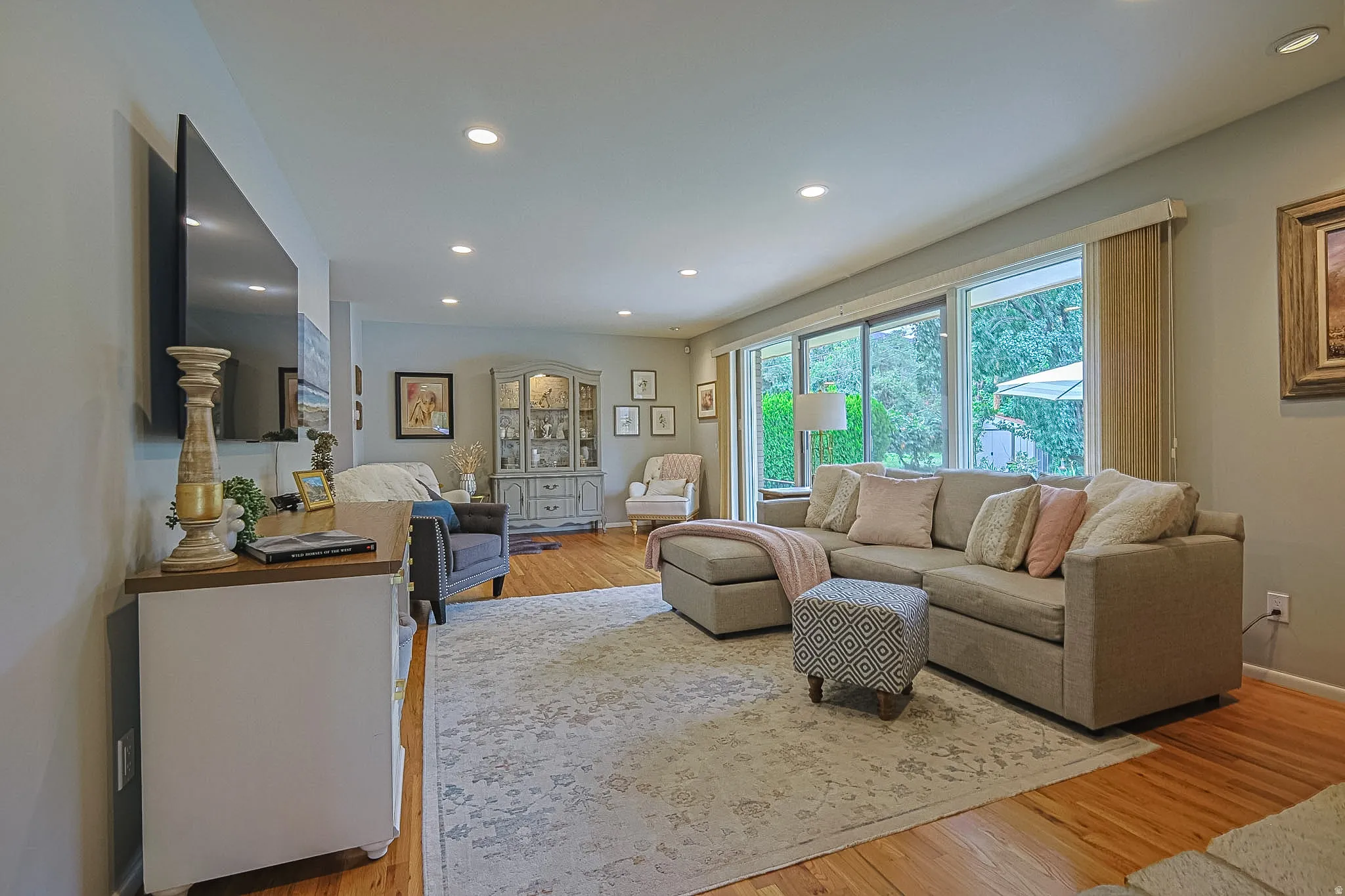 Recessed ceiling lighting, hardwood flooring, expansive wall of windows, and light-toned wall finishes