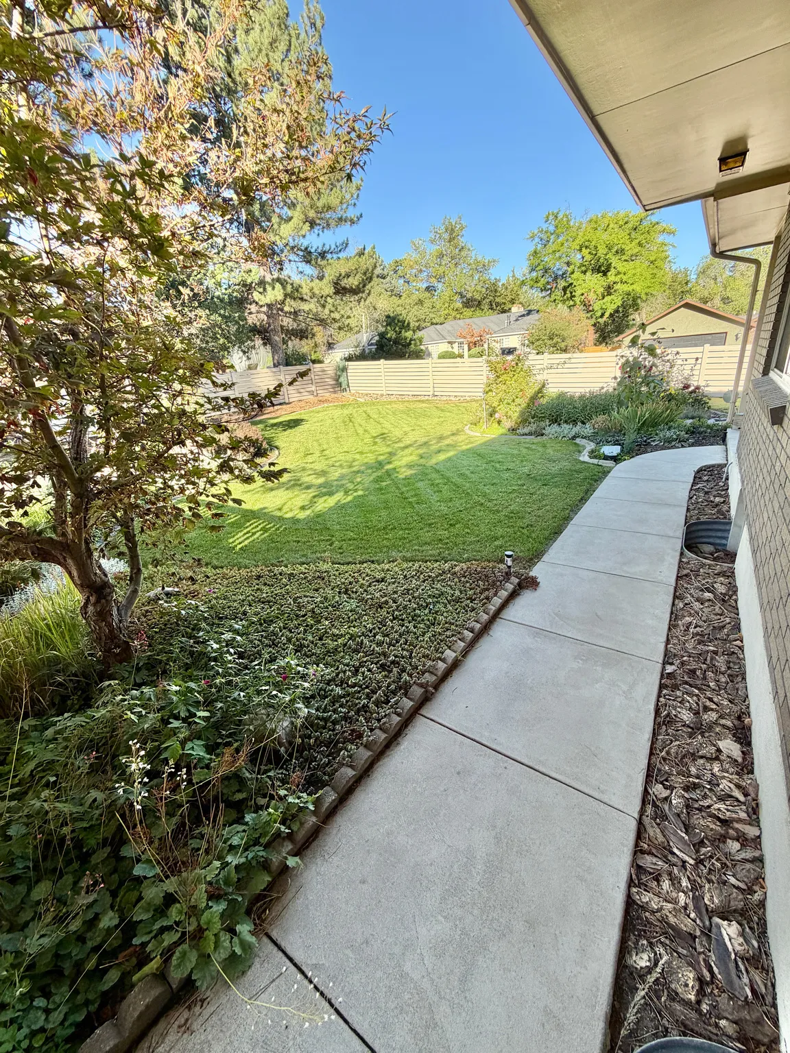 Expansive lawn area with mature trees and established landscaping