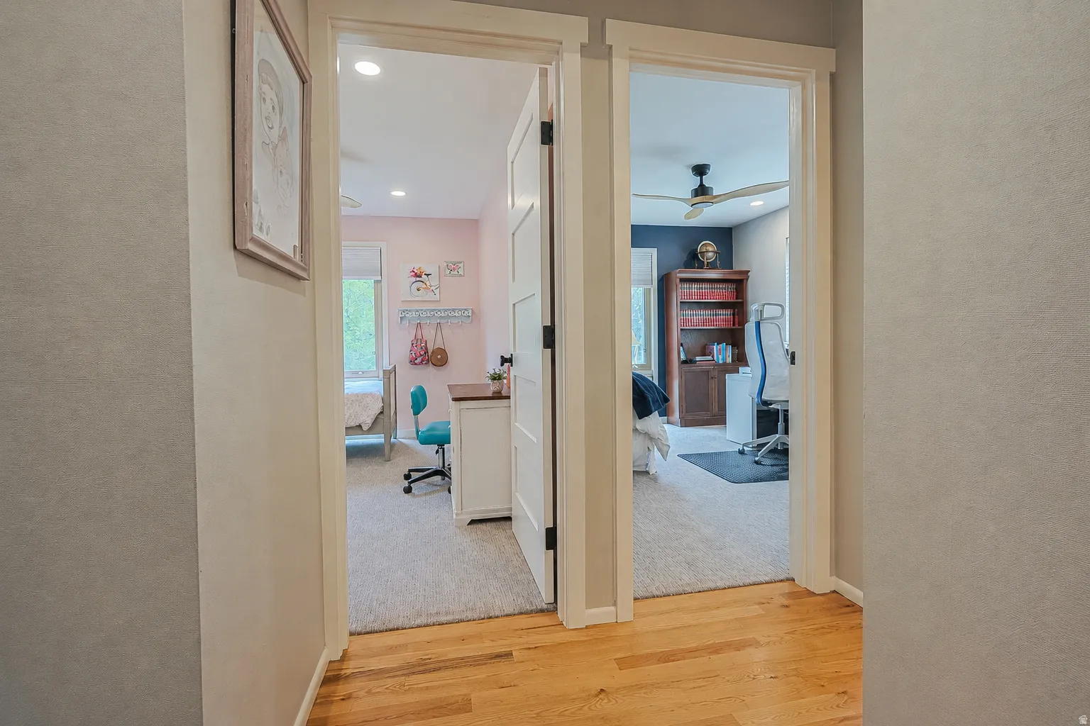 Wood-finish flooring with light-colored carpeting in adjacent rooms