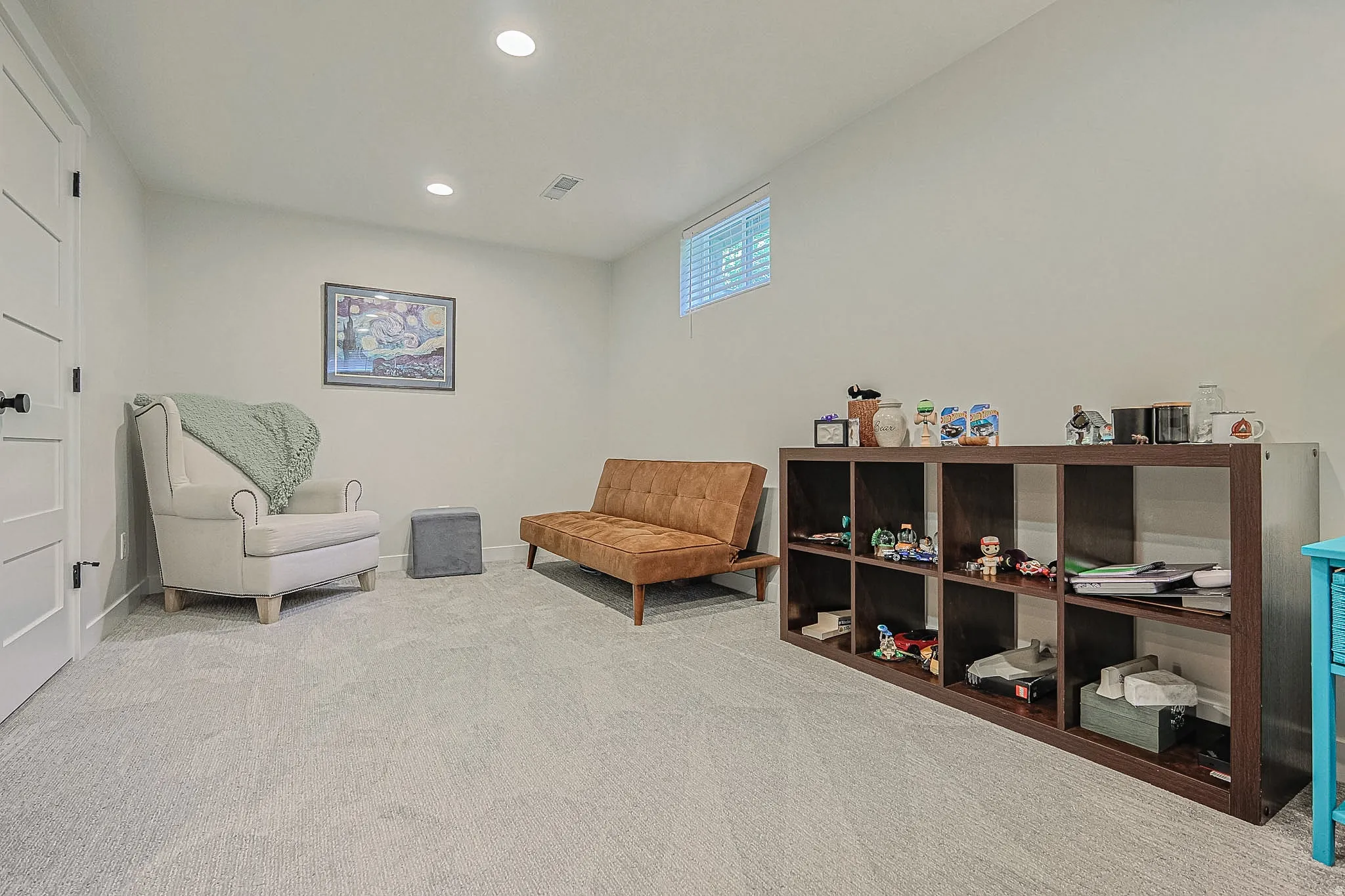 Recessed ceiling lighting, light-colored carpeting, white interior doors with black hardware, and a high-set window