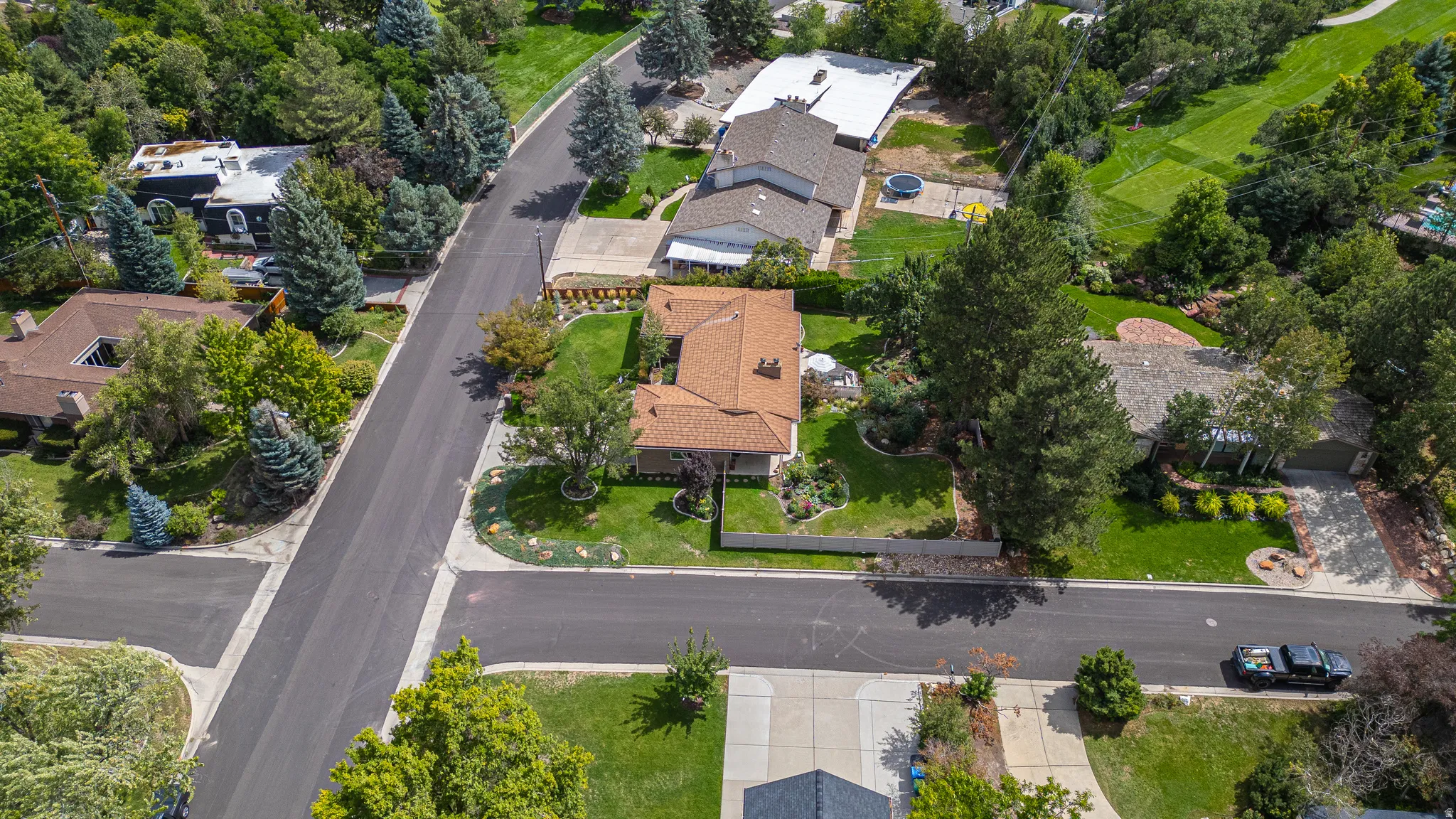 Paved street with mature trees and landscaped properties