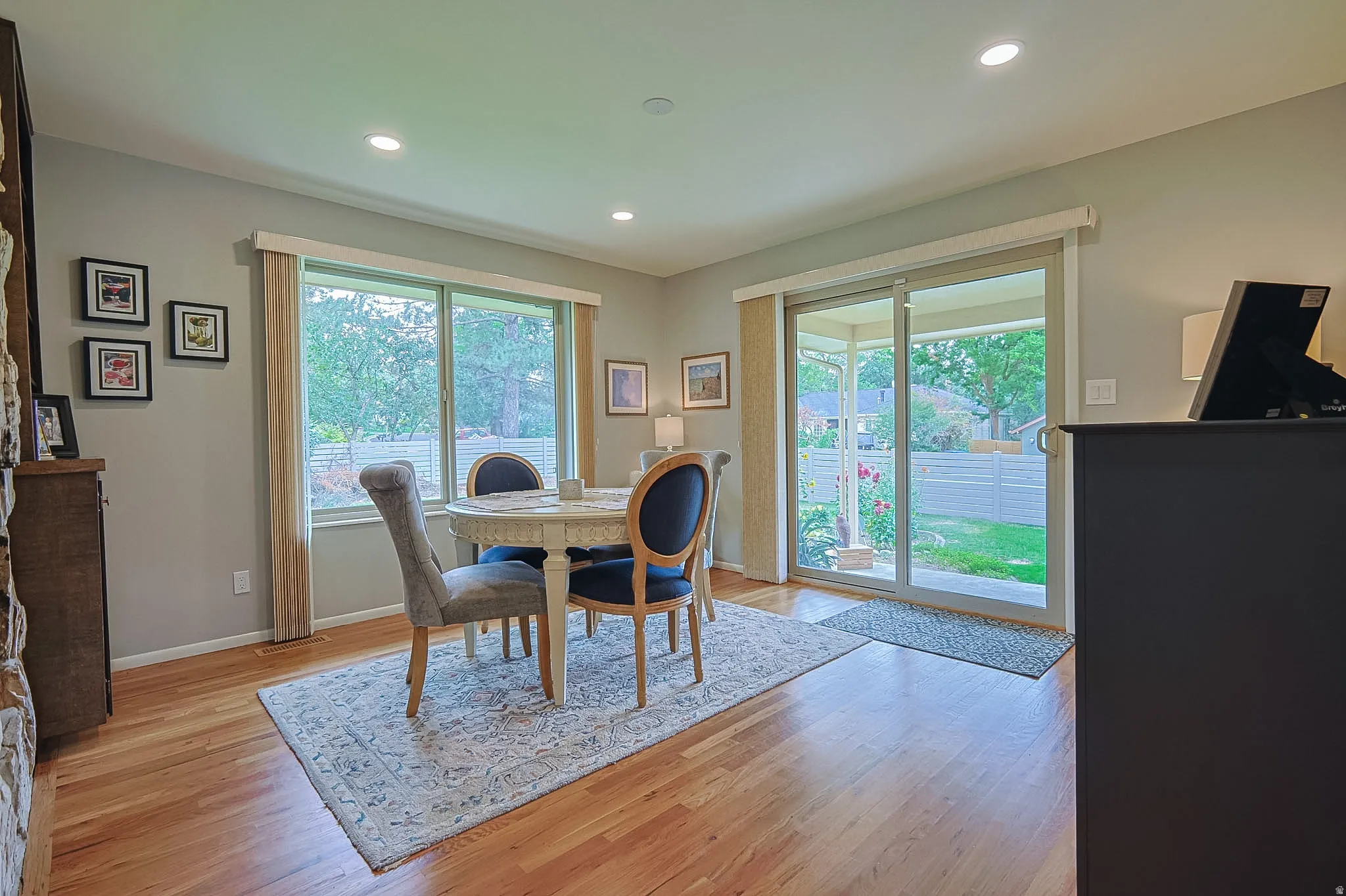 Hardwood flooring, recessed lighting, expansive windows, sliding glass door access to exterior, and a stone-faced built-in cabinet