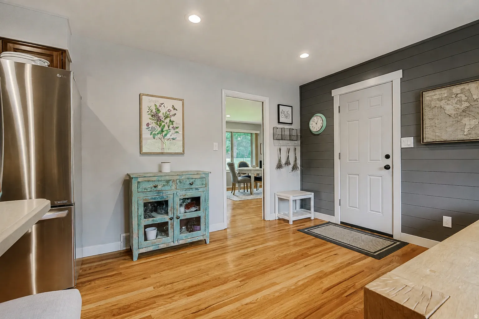 Hardwood flooring, recessed lighting, stainless steel refrigerator, shiplap accent wall, paneled interior door