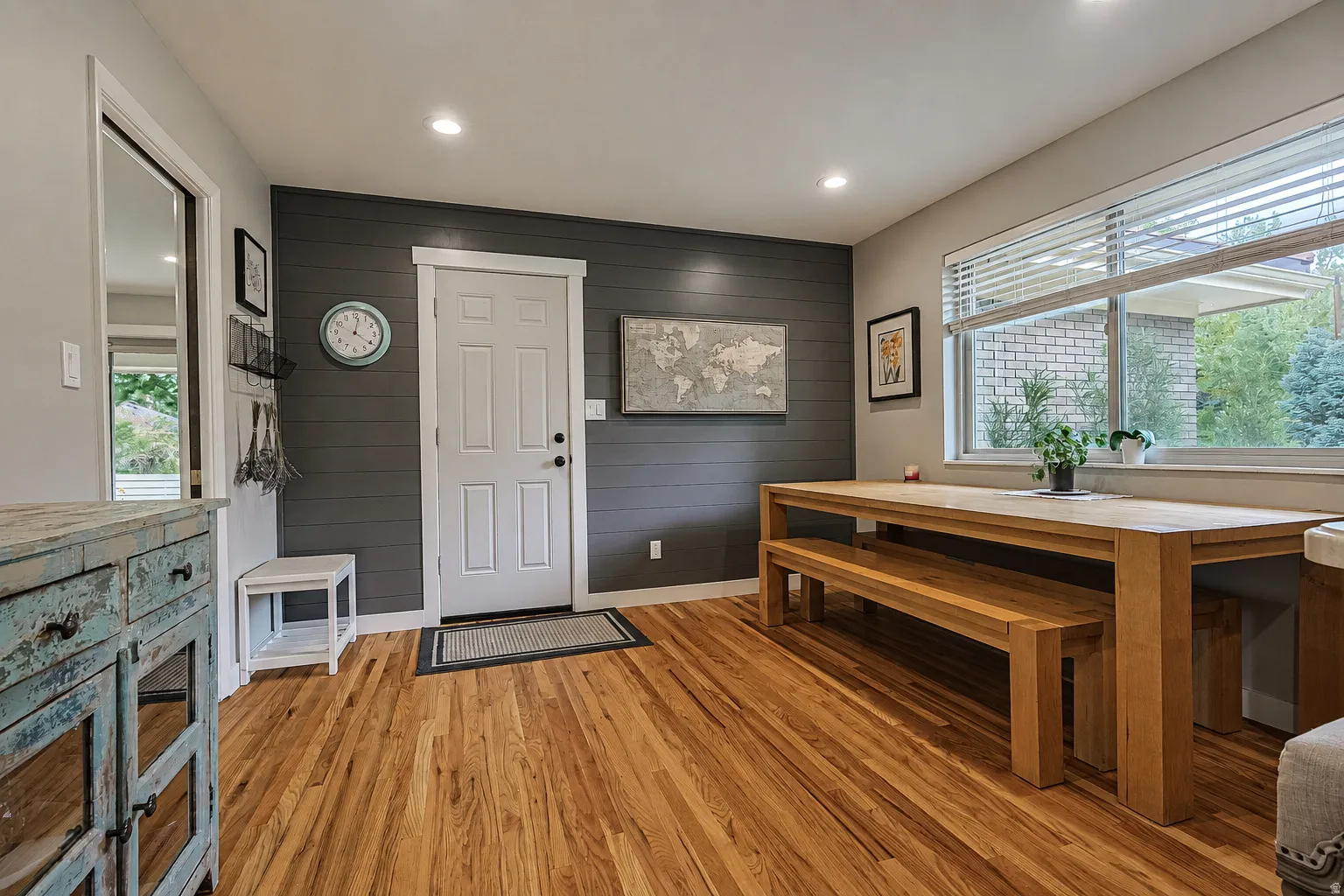 Wood-finish flooring throughout, complemented by a shiplap accent wall