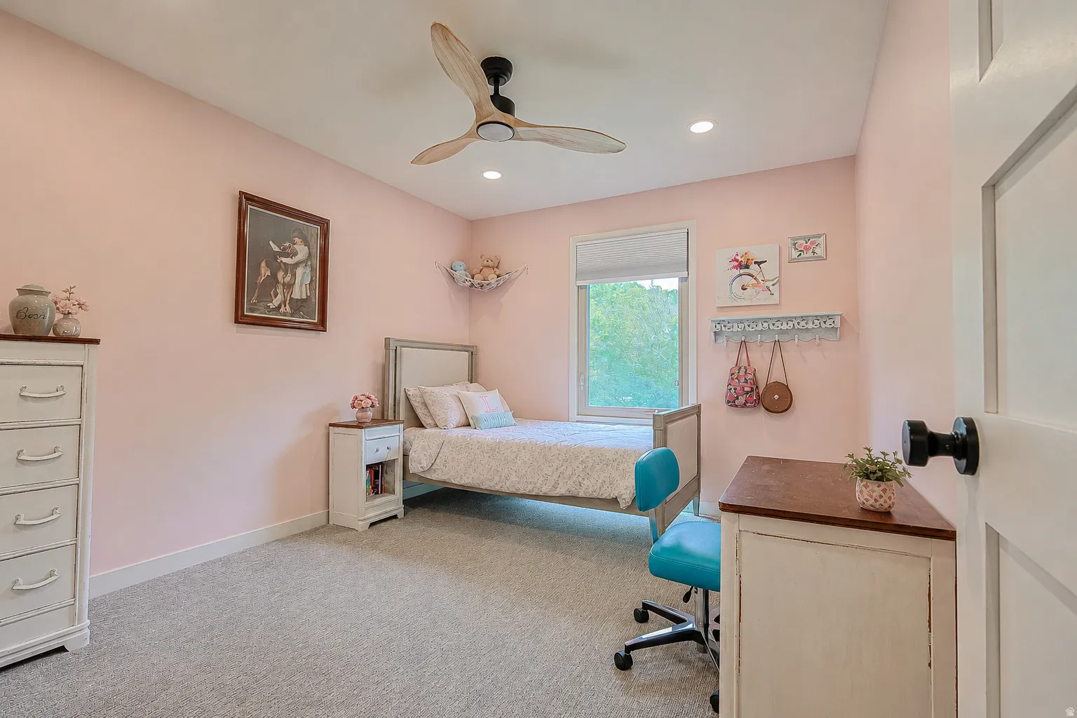 Recessed lighting, wood-finish ceiling fan, window with roller shade, paneled door with black hardware, and wall-to-wall carpeting