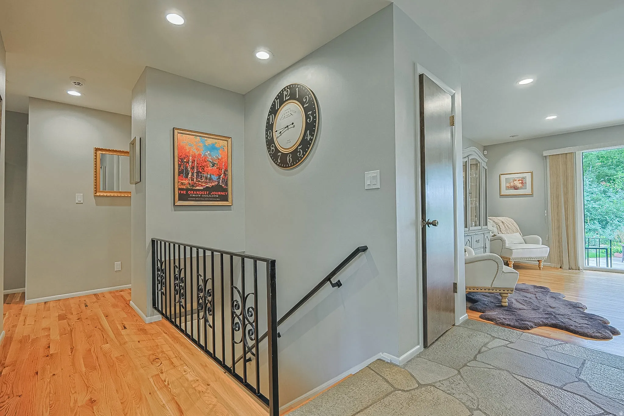 Hardwood flooring, recessed lighting, wrought iron railing, sliding glass door, and stone tile entry