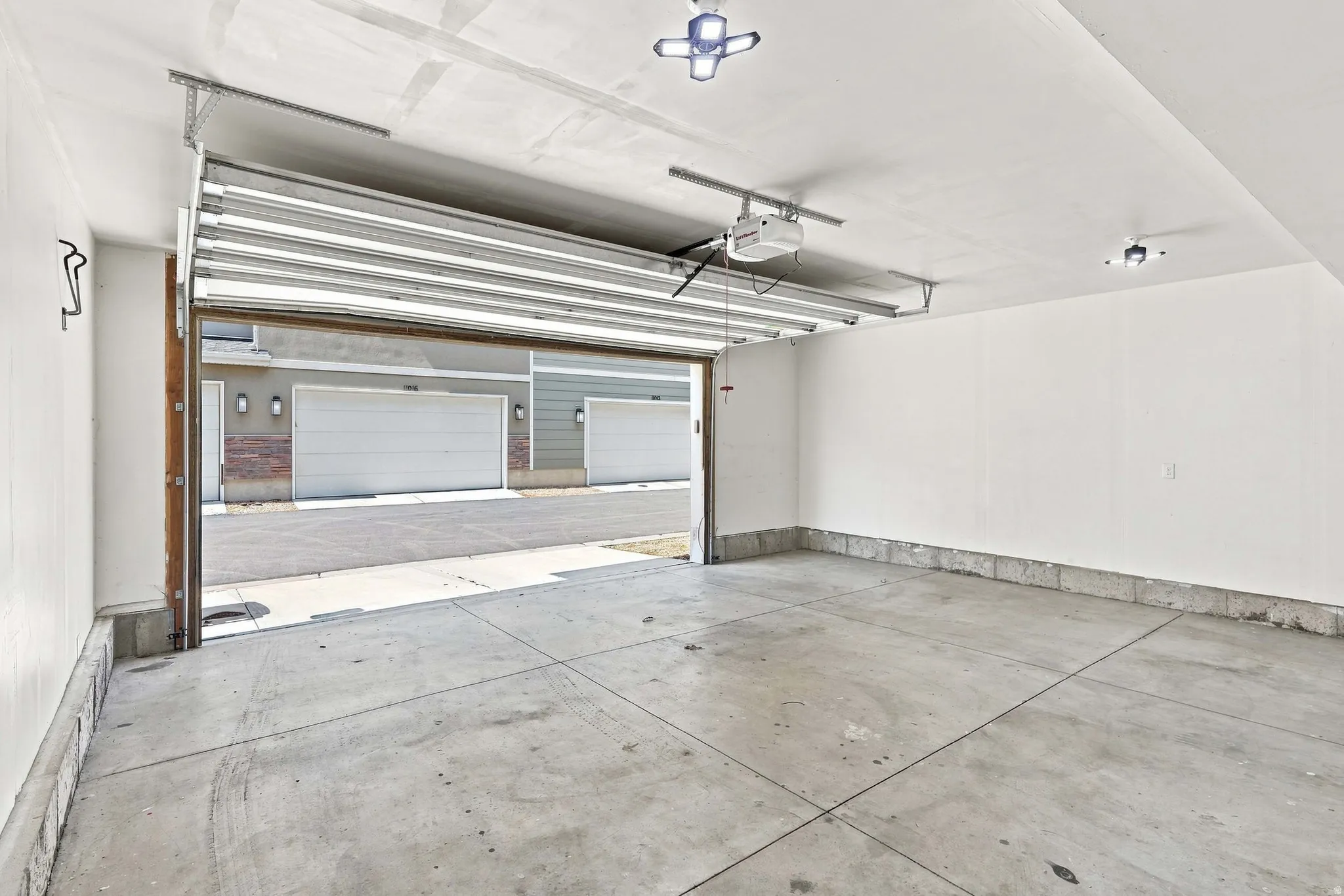 Spacious garage with concrete flooring, automatic garage door opener, and overhead lighting