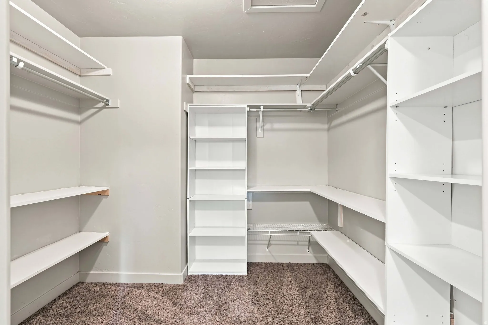 Custom closet system featuring extensive white shelving and hanging rods